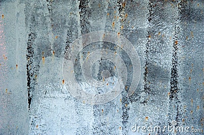 Faded from time and weather painted white on a black primer metal surface with cracks, stains and rust. Background, structure. Stock Photo