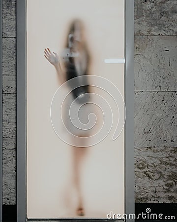 Faded woman silhouette behind the frozen glass door Stock Photo