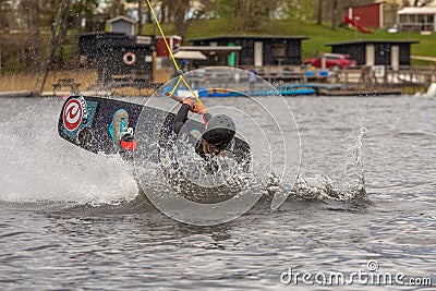 Fagersta, Sweden - Maj 07, 2020: Girl teenager wakeboarding fells into the water after an unsuccessful jump Editorial Stock Photo