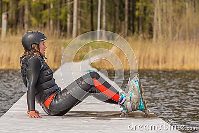 Fagersta, Sweden - Maj 07, 2020: Teen girl wakeboarde is resting on the pier Editorial Stock Photo