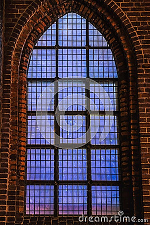 Faint blue light coming from a church Gothic window conveys a celestial, deep feeling with profund, intense and abyssal concept Stock Photo