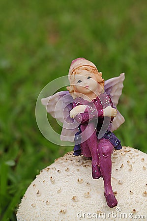 A fairy figurine on a mushroom in the garden Stock Photo