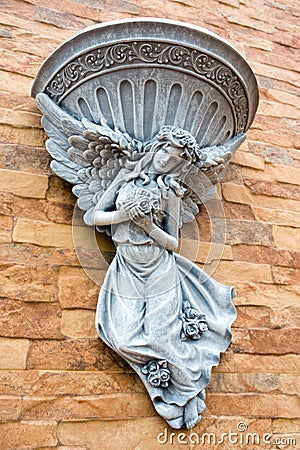 Fairy statue and fountain basin decorate on the wall Stock Photo