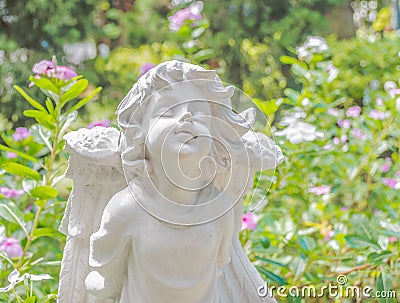 Fairy Statue in the garden with flower Stock Photo
