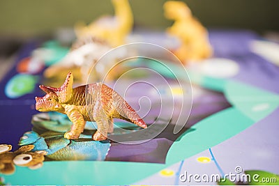 A fairy tale about dinosaurs in a book with text and toys in . Stock Photo