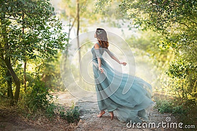 Fairy-tale princess in light summer blue turquoise dress on wide path Stock Photo