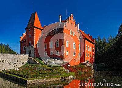 Fairy tale red castle on the lake, with dark blue sky, state castle Cervena Lhota, Czech republic Stock Photo