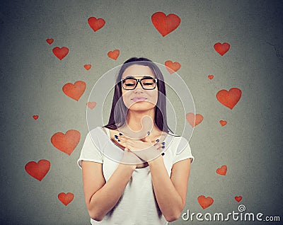 Faithful woman with eyes closed keeps hands on chest near heart Stock Photo