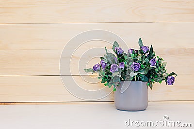 Fake flower in vase on wood background. Stock Photo