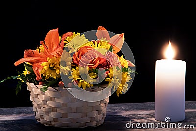 Fall Flower Bouquet with Lilies and Daisies and candles on wooden floor and black background Stock Photo