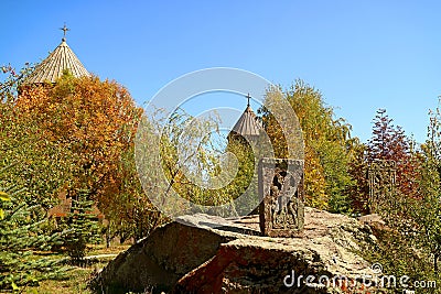 Fall foliage in the church courtyard with the ancient khachkar or Armenian cross-stone Stock Photo