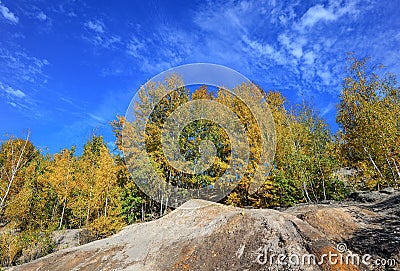 Fall nature background. Trees wiht yellow leaves, bright blue sky and granite mountains. Stock Photo