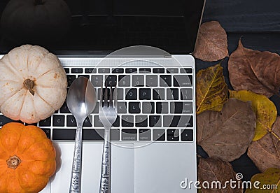 Fall Thanksgiving and Halloween pumpkins, dry leaves and have laptop computer Stock Photo