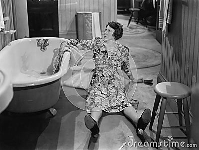 Fallen woman on floor next to bathtub Stock Photo