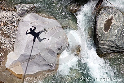 Falling bungee jumper shadow above mountain river Stock Photo