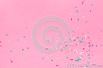 Falling down trendy futuristic neon sprinkles on pink background Stock Photo