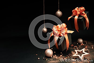 Falling gift boxes with orange ribbon, balls and glitter gold confetti, star with copy space. Stock Photo