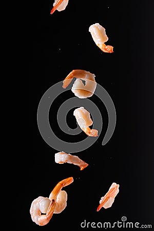 Falling shrimp on a black background, close-up. Seafood, wholesome food, culinary background Stock Photo