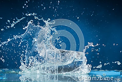 Falling small glasses and spilling water on a blue background Stock Photo
