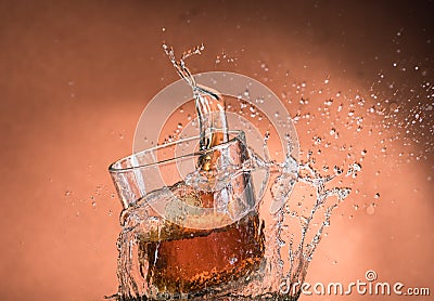 Falling small glasses and spilling water on a green background Stock Photo