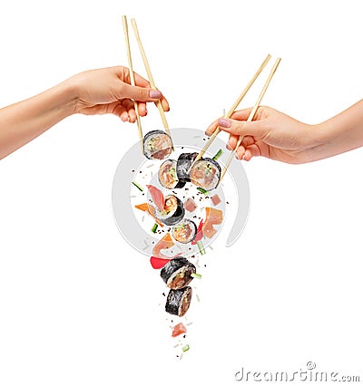 Falling sushi rolls with wooden chopsticks in female hands, isolated on white background Stock Photo