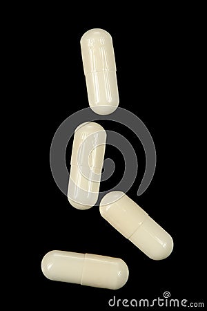 Falling White Pills on Black Background Stock Photo