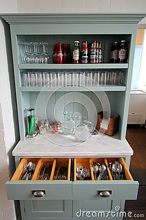 Falmouth, Cornwall, UK - April 12 2018: Self service cutlery, glasses, water and sauces on an antique dresser in a cafe Editorial Stock Photo