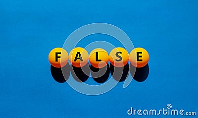 False symbol. Orange table tennis balls with the words `false`. Beautiful blue background, copy space. Warm sunshine. Business, Stock Photo