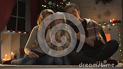 Famiglia che mangia i biscotti dolci sul pavimento, sull'albero di Natale e sulle luci scintillanti, vigilia video d archivio Famiglia che mangia i biscotti dolci sul pavimento, sull'albero di Natale e sulle luci scintillanti, vigilia video d archivio