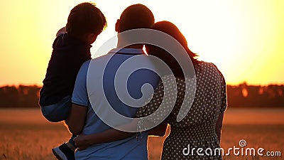 Famiglia felice che guarda il tramonto, stante in un giacimento di grano Un uomo che tiene un bambino nelle sue armi Una donna ab archivi video Famiglia felice che guarda il tramonto, stante in un giacimento di grano Un uomo che tiene un bambino nelle sue armi Una donna ab archivi video