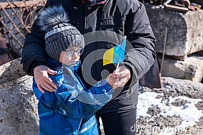 Upset Ukrainian boy with his grandmom, with bue yellow flag, protesting war conflict. Editorial Stock Photo