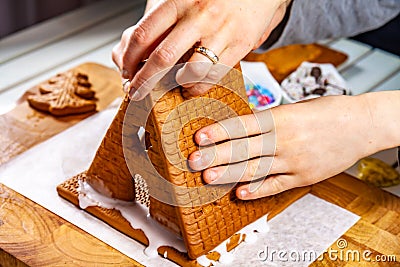Familiy building a sweet ginger bread house Stock Photo