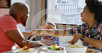 Famille ayant la nourriture à la table de salle à manger dans une maison confortable 4k banque de vidéos Famille ayant la nourriture à la table de salle à manger dans une maison confortable 4k banque de vidéos