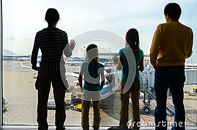 Family in airport, travel concept, silhouettes of parents with kids in terminal waiting for flight Stock Photo
