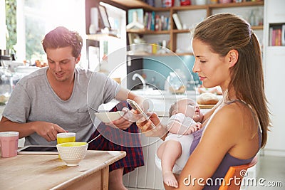 Family With Baby Girl Use Digital Devices At Breakfast Table Stock Photo