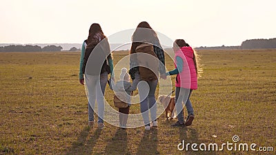 Family with backpacks travels with a dog. teamwork of a close-knit family. mother, daughters and home pets tourists Stock Photo