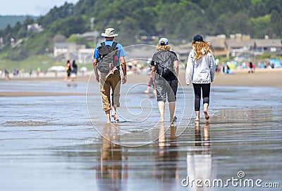 A family with backpacks travels on the water on the shore of the Northwest Pacific Editorial Stock Photo