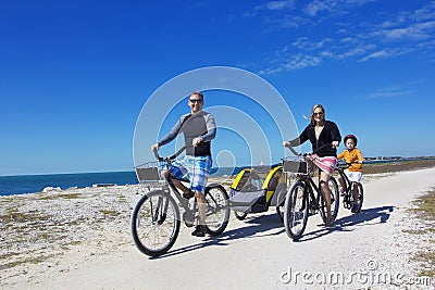 Family on a beach bicycle ride together Stock Photo