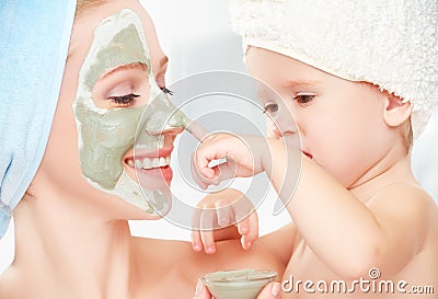 Family beauty treatment in the bathroom. mother and daughter baby girl make a mask for face skin Stock Photo