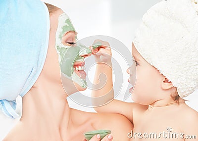 Family beauty treatment in bathroom. mother and daughter baby girl make mask for face skin Stock Photo