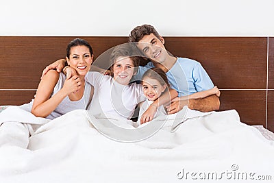 Family on bed bedroom, couple parents children Stock Photo