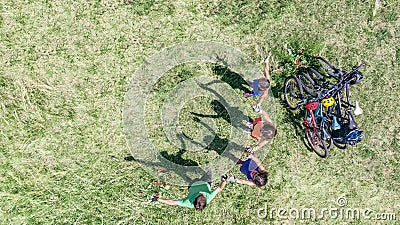 Family on bikes cycling outdoors, active parents and kids on bicycles, aerial top view of happy family with children Stock Photo