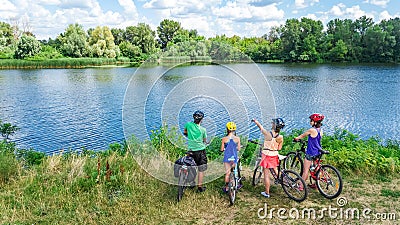Family on bikes cycling outdoors, active parents and kids on bicycles, aerial view of family with children Stock Photo