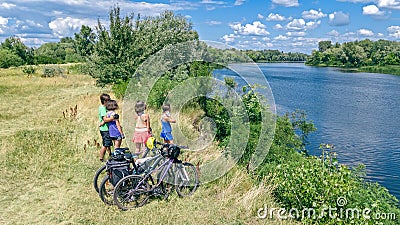 Family on bikes cycling outdoors, active parents and kids on bicycles, aerial view of happy family with children relaxing Stock Photo