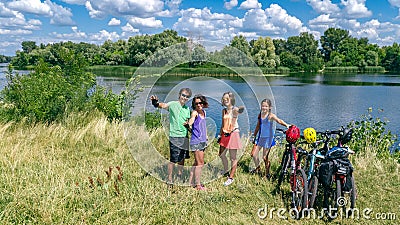 Family on bikes cycling outdoors, active parents and kids on bicycles, aerial view of happy family with children relaxing Stock Photo