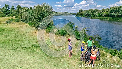 Family on bikes cycling outdoors, active parents and kids on bicycles, aerial view of happy family with children relaxing Stock Photo