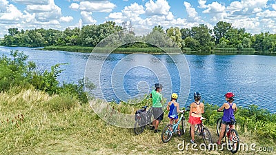 Family on bikes cycling outdoors, active parents and kids on bicycles, aerial view of happy family with children relaxing Stock Photo
