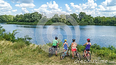 Family on bikes cycling outdoors, active parents and kids on bicycles, aerial view of happy family with children relaxing Stock Photo