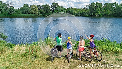 Family on bikes cycling outdoors, active parents and kids on bicycles, aerial view of happy family with children relaxing Stock Photo