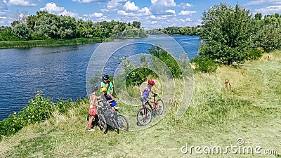 Family on bikes cycling outdoors, active parents and kids on bicycles, aerial view of happy family with children relaxing Stock Photo